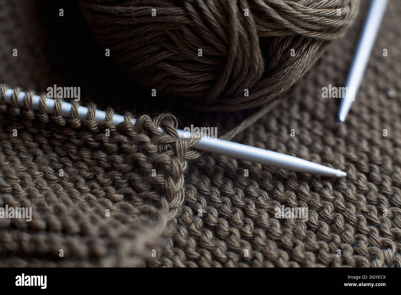 A pair of knitting needles, knitting and a ball of yarn, full frame Stock Photo