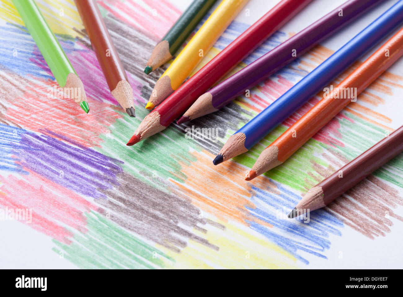 Colored pencils lying on a drawing with colored scribbles Stock Photo