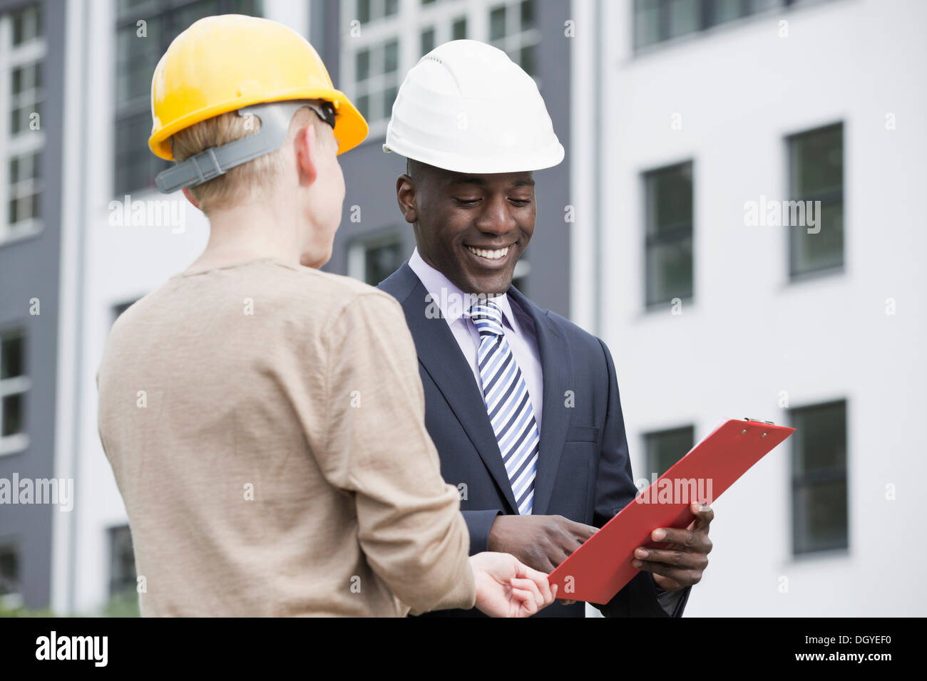 Businessman happily giving directions to manual worker Stock Photo