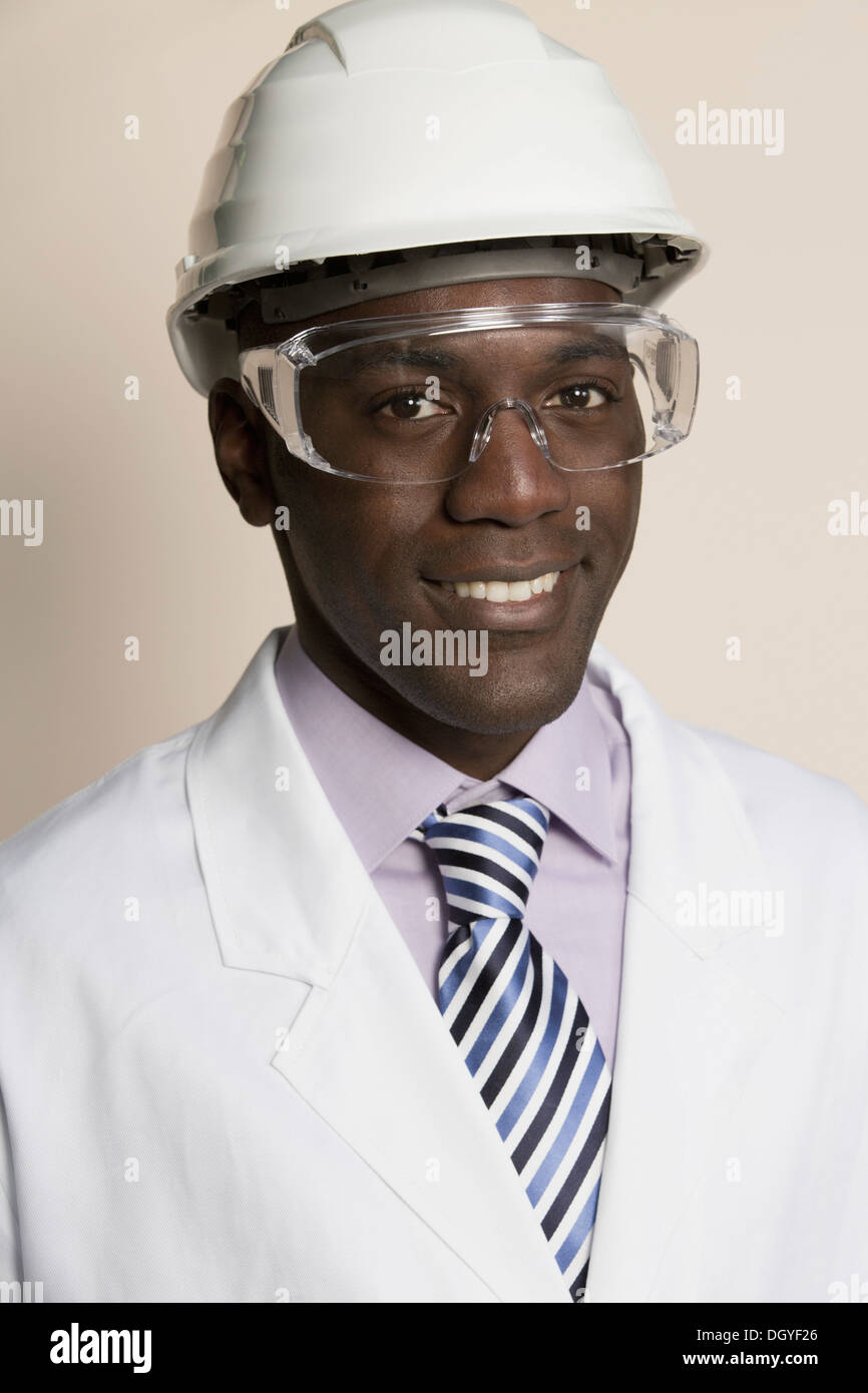 Laboratory worker wearing hard hat, protective goggles and lab coat