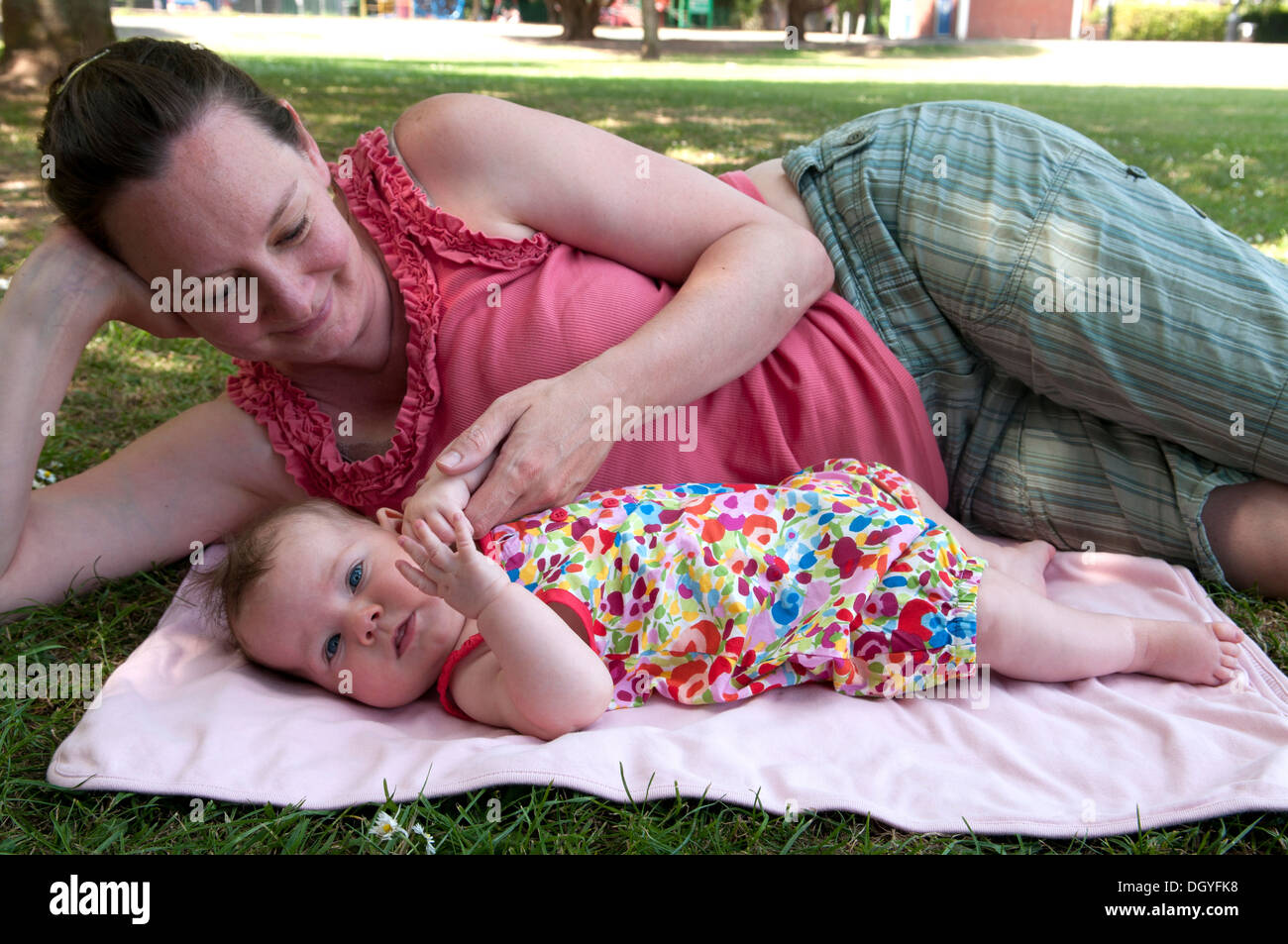 Mother cuddling her baby girl outside in the garden Stock Photo Alamy