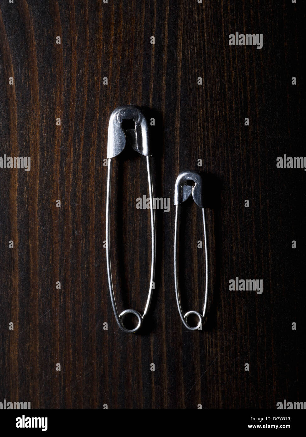 Two different sized safety pins, side by side Stock Photo