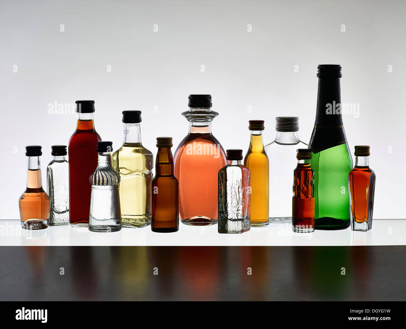 A grouping of various miniature bottles of alcohol without labels, back lit Stock Photo