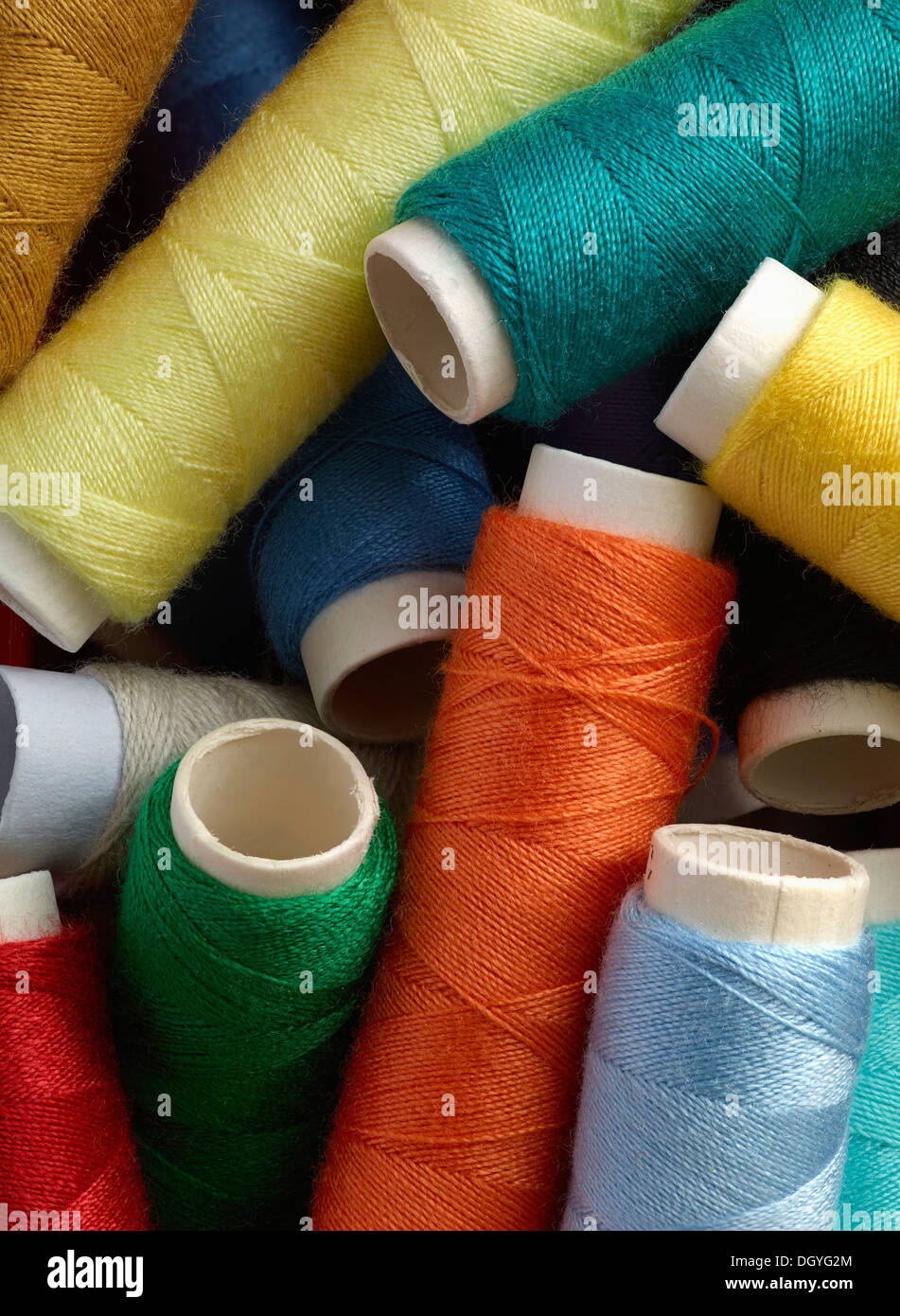 A pile of different colored spools of thread, close-up, full frame Stock Photo