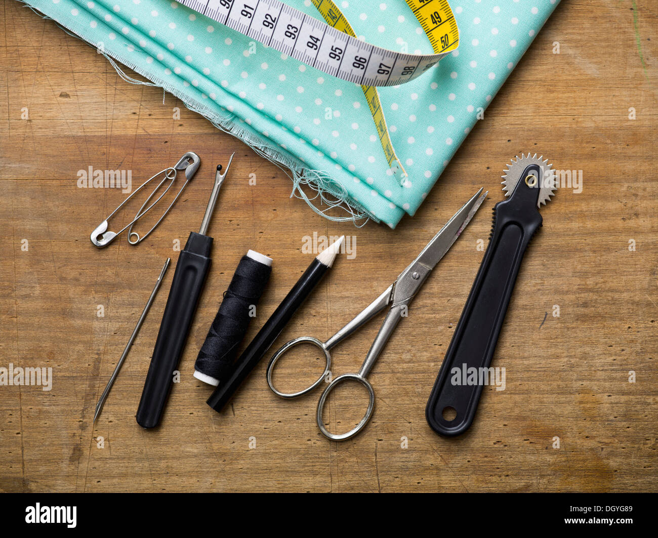 Various sewing equipment arranged on a wooden surface Stock Photo