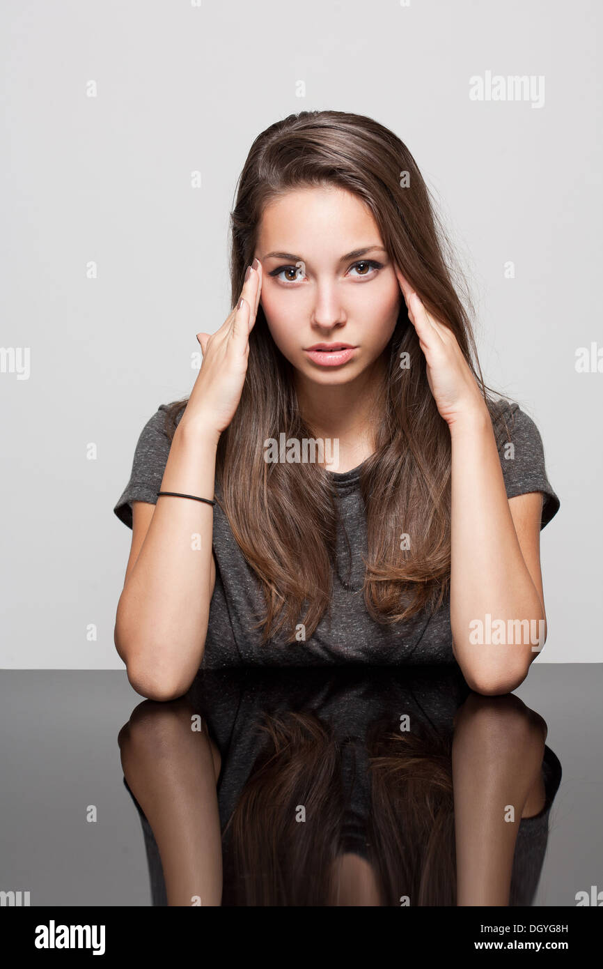 Portrait of a young brunette woman with gesture showing pain Stock ...