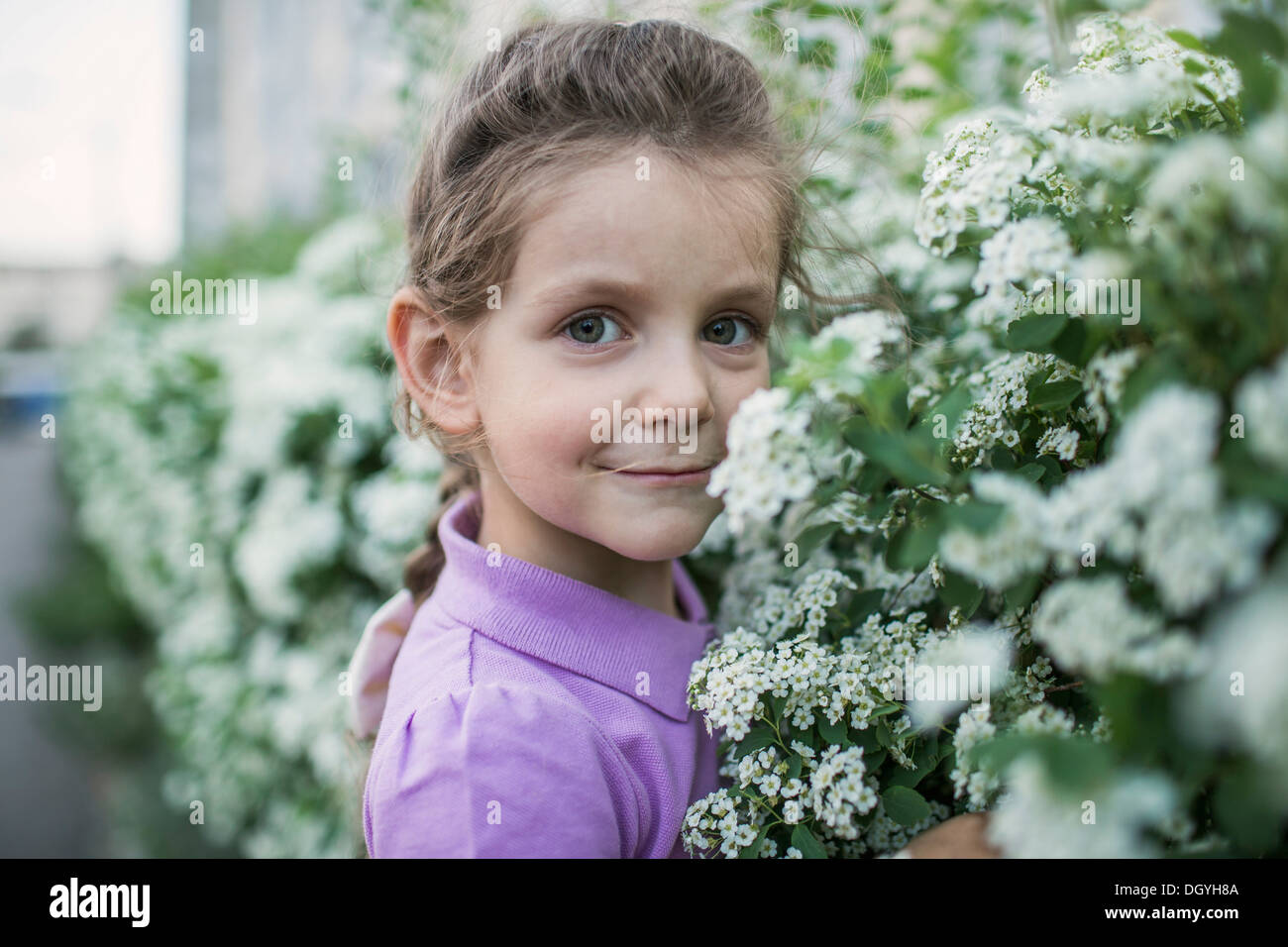 A young girl smelling flowers Stock Photo