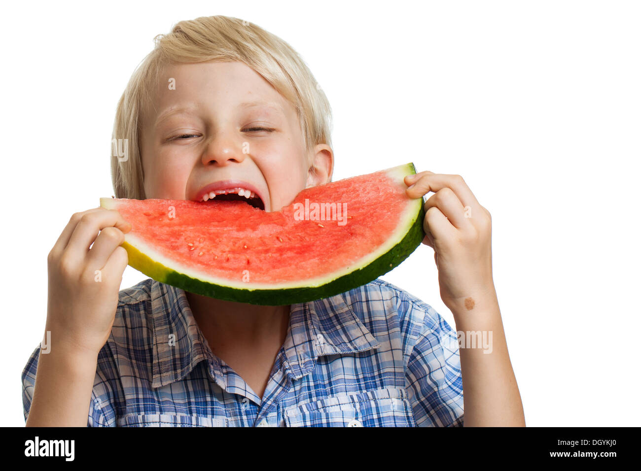 A young boy taking big bite of juicy slice of watermelon. Isolated on white. Stock Photo