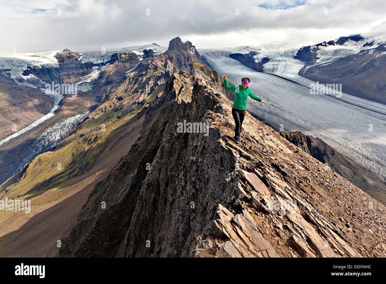 Mountaineer on the summit ridge in front of a glacier tongue