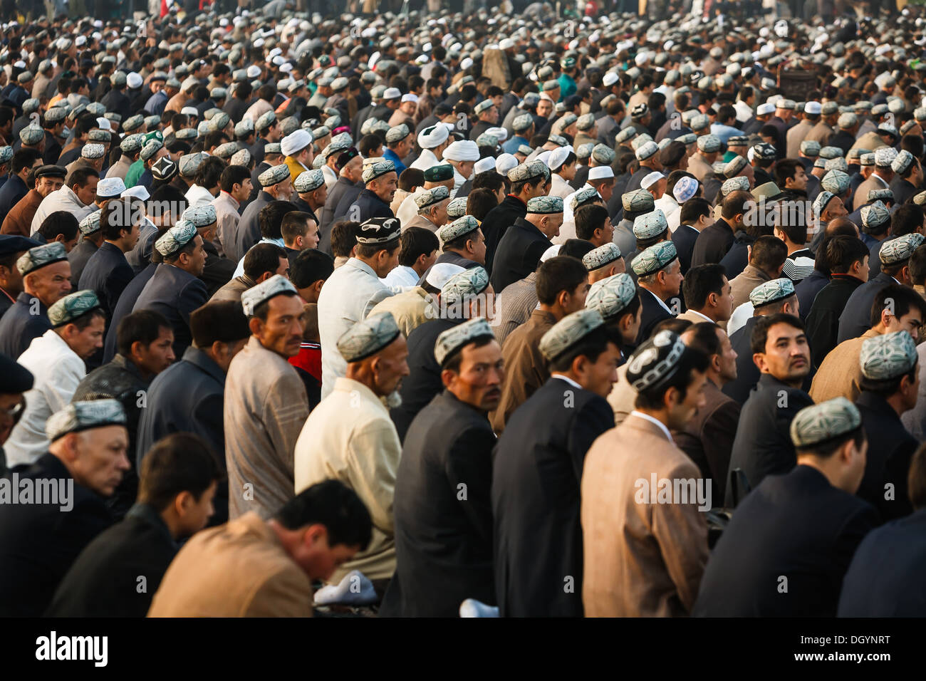 Thousands of muslim worshipers kneel on prayer carpets outside of Id Kah Mosque at the end of Ramadan Kashgar, Xinjiang province Stock Photo