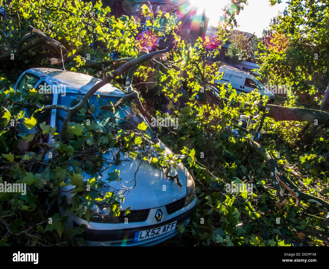 Nightingale Lane, Clapham, London, UK  . 28th Oct, 2013. Part of a tree falls on a Jaguar saloon car as a result of the storm. The interior of the car appears undamaged so it is presumed the occupants abandoned their car as it is not in a parking space but in the middle of its lane. Another car in a parking space across the road is also damaged. Commuters and school children, on their way to a delayed Northern Line at Clapham South, stop to look and take pictures.The storm, called St Jude, brought the windiest weather to hit the UK since 1987. Credit:  Guy Bell/Alamy Live News Stock Photo
