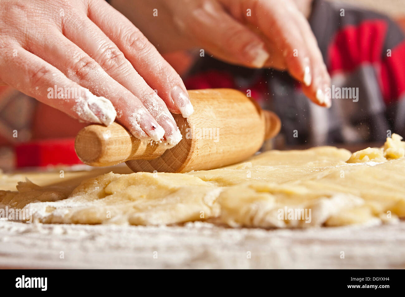 Woman's hands rolling dough with a rolling pin Stock Photo