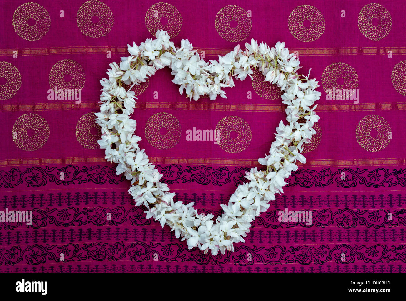 Heart shape Jasmine flower garland on a colourful Indian sari Stock Photo