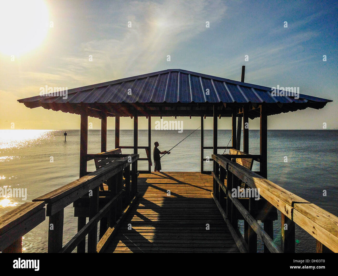 Caucasian man fishing off wooden dock - Smartphone Captured Stock Image