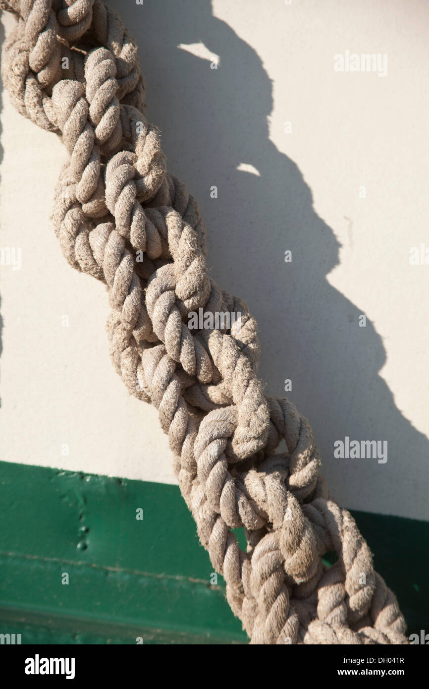 Knotted rope, detail view of a small sailing ship in the harbour of ...