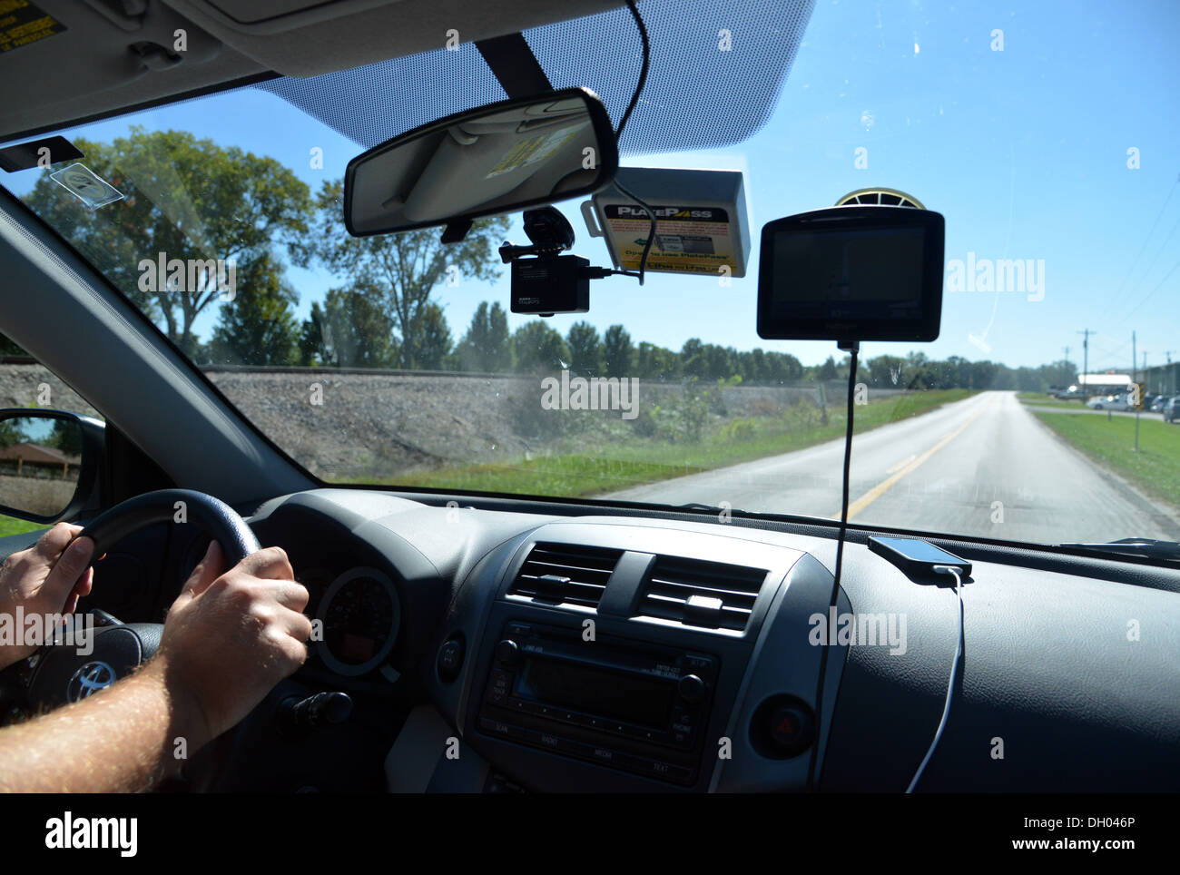 Electronics in car dash. Driver on old Route 66 with Sat Nav, mobile phone, dash cam and toll road pass. (TomTom goPro iPhone) Stock Photo