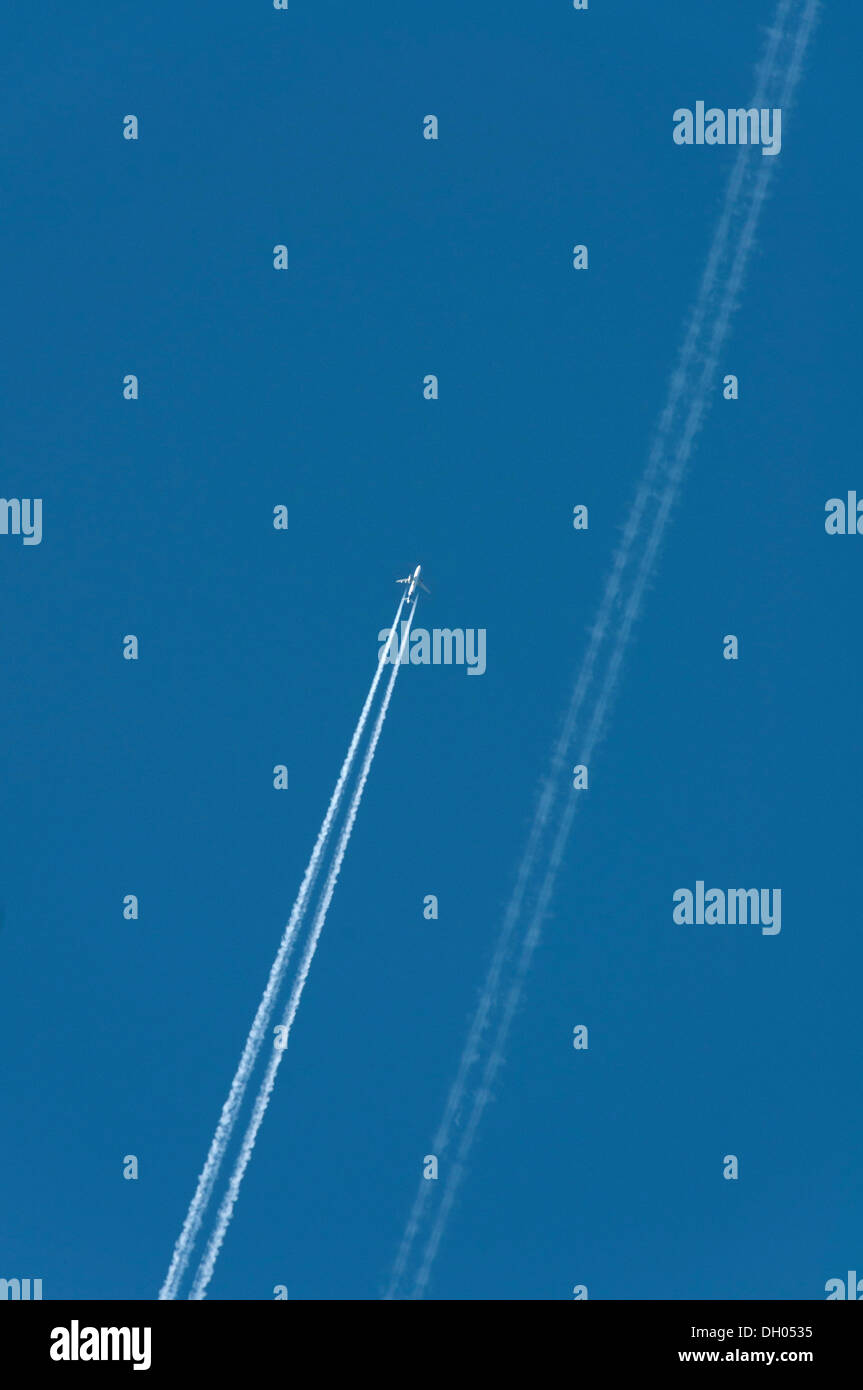 Aircraft with contrails in the sky Stock Photo