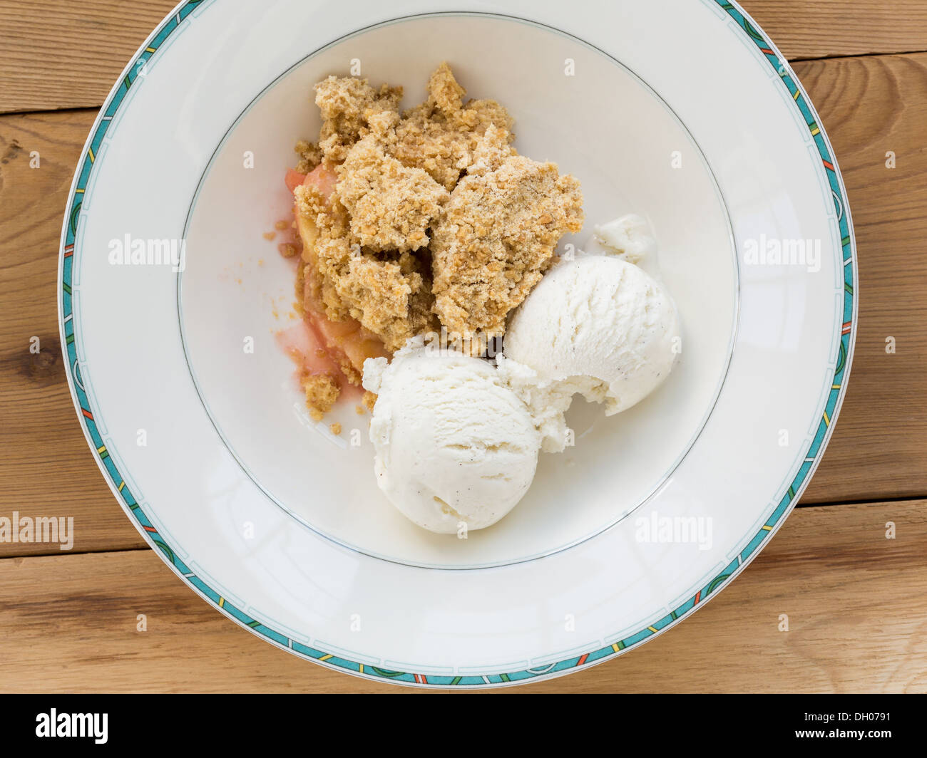 Apple and strawberry crumble and ice cream dessert pudding in a bowl, overhead view Stock Photo