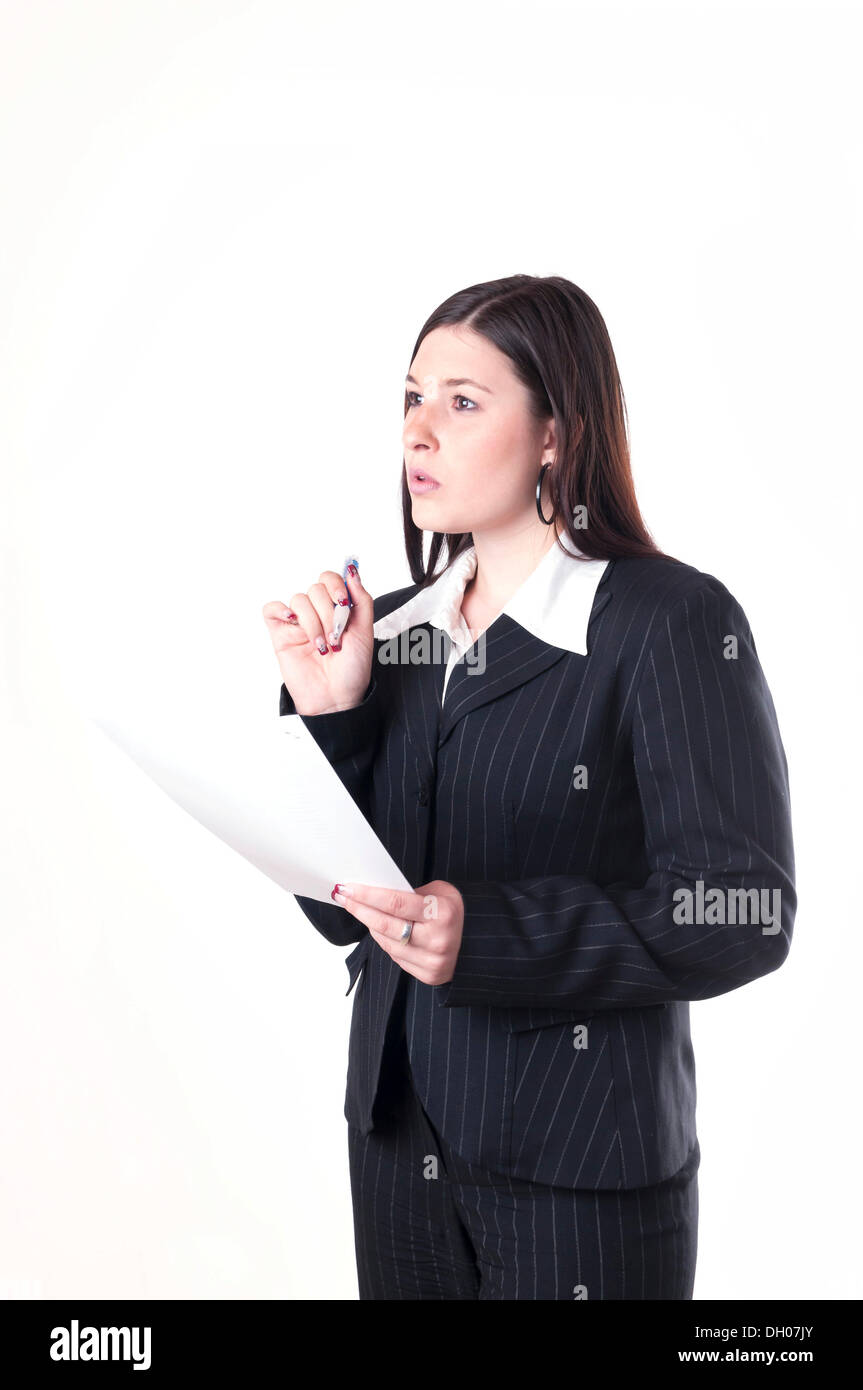Businesswoman holding a pen and a letter, pondering Stock Photo