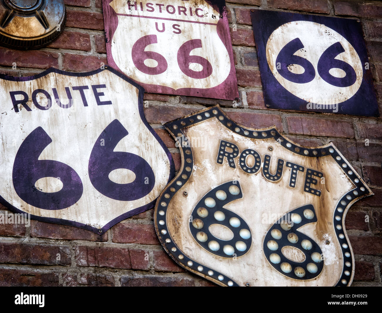 A Collection of vintage Route 66 signs displayed on a old brick wall. Stock Photo