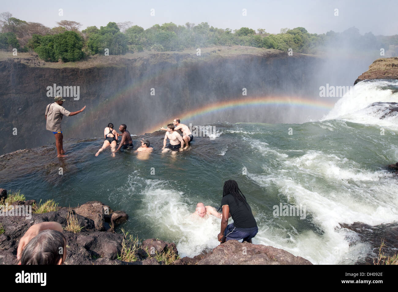 Devils Pool Victoria Falls;  Zambia side, people on an adventure holiday swimming on the edge of the Falls in Devil's Pool, Zambia Africa Stock Photo