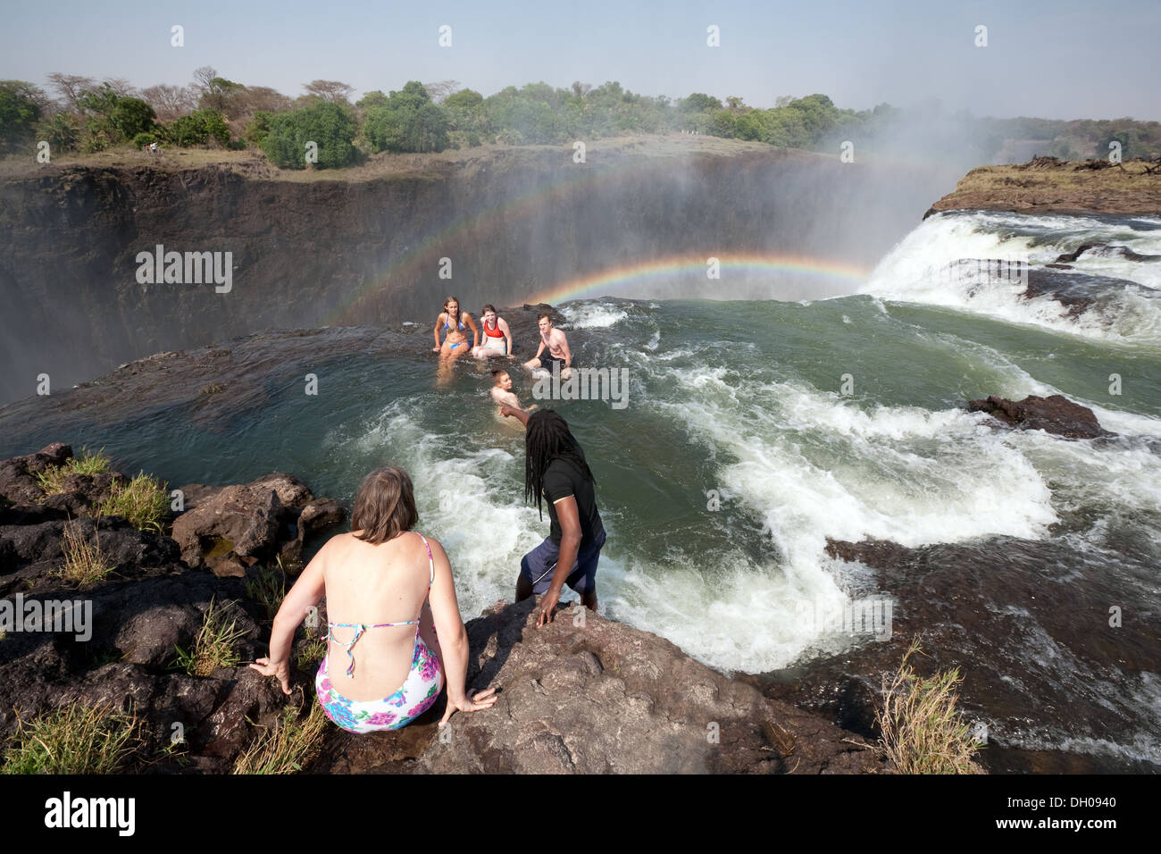 People swimming in Devils Pool at the edge of the Victoria Falls, Adventure travel in Zambia Africa Stock Photo