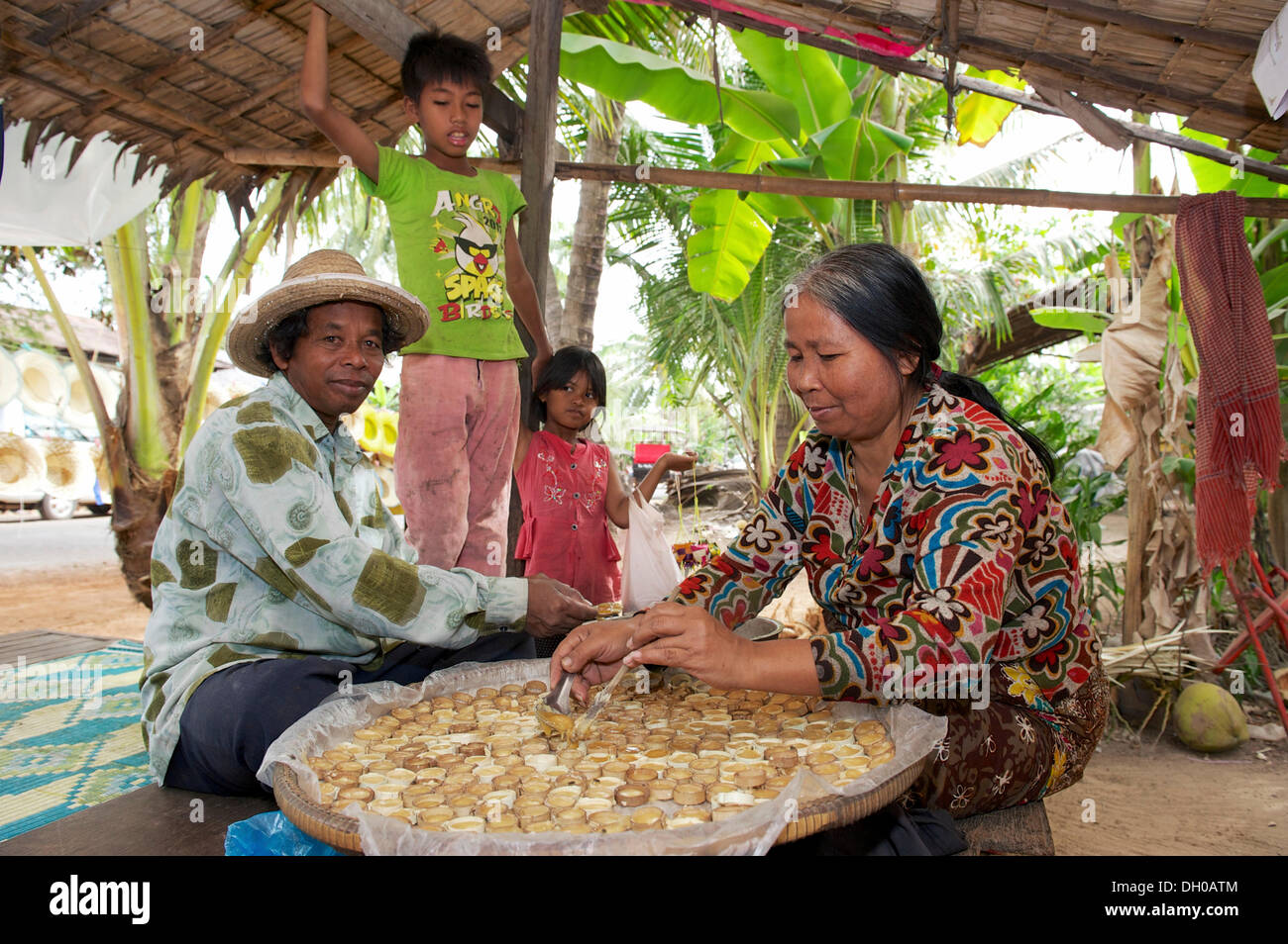Woman pouring hot palm sugar in forms made of bamboo, Siem Reap, Siem Reap, Siem Reap Province, Cambodia Stock Photo