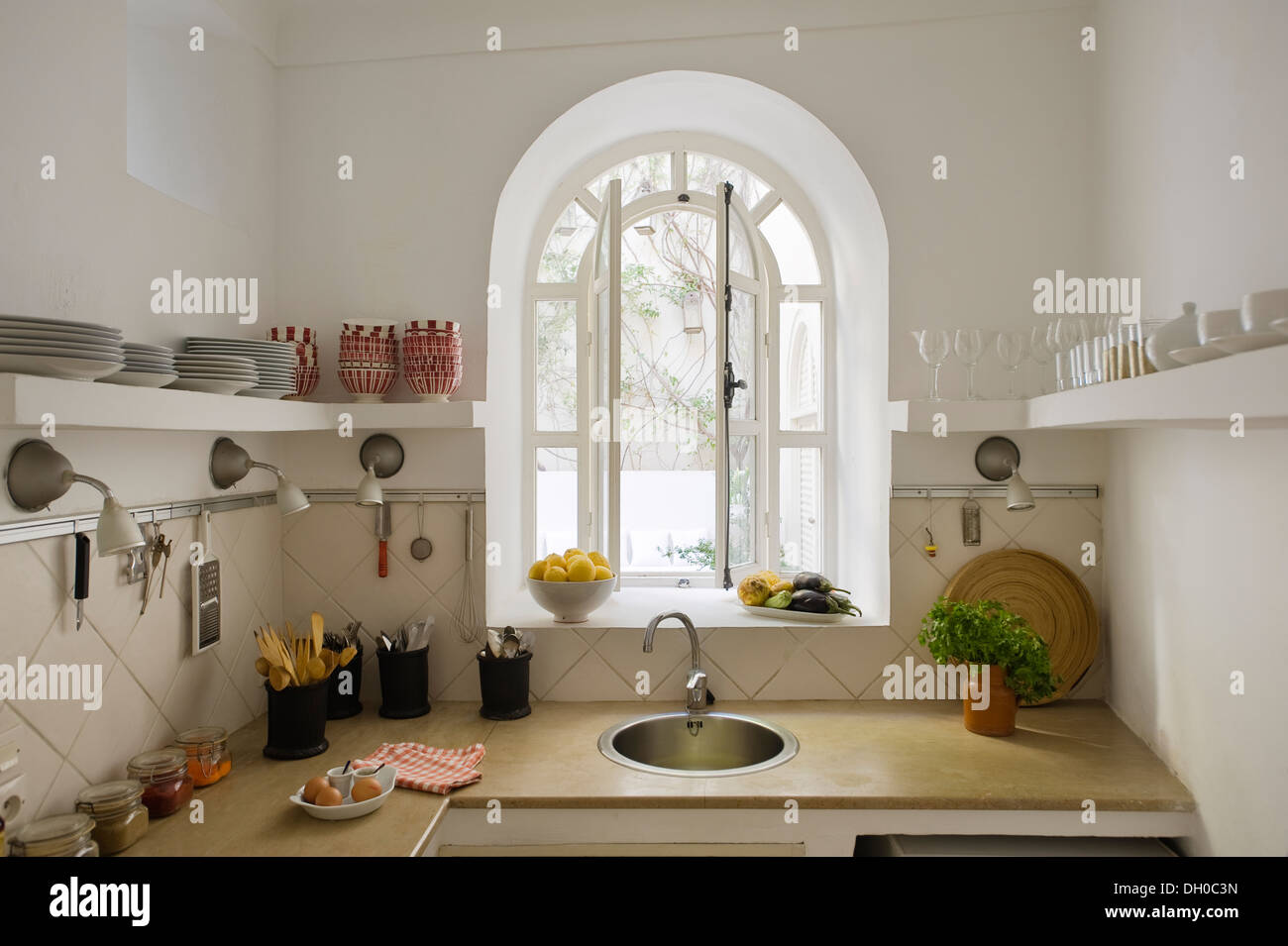 Modern Moroccan kitchen with arched window and view to internal courtyard Stock Photo