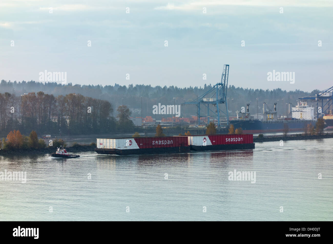 tugboat towing barge with oversize Seaspan containers, Fraser river, New Westminster, British Columbia, Canada Stock Photo