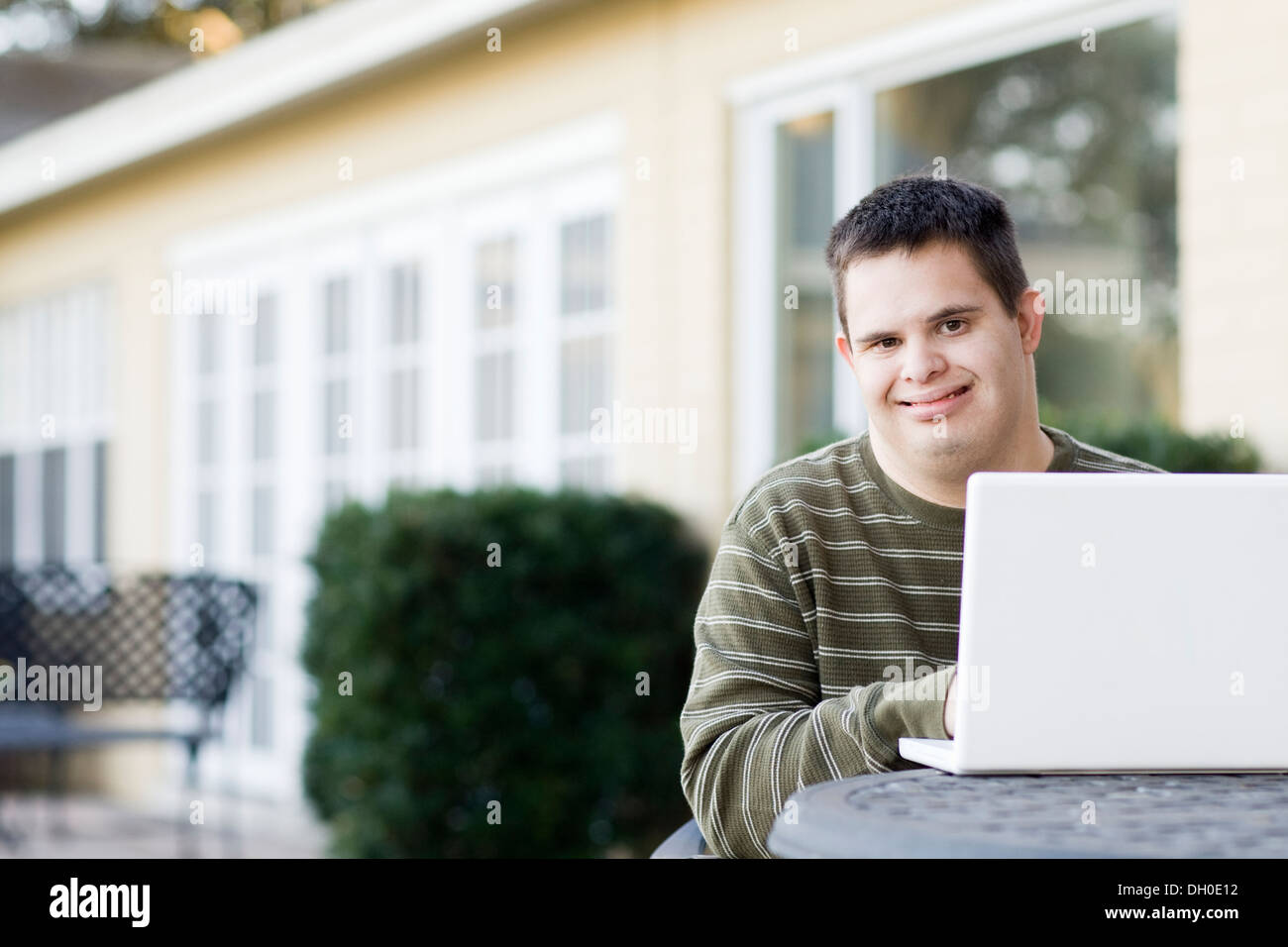 Disabled Caucasian man using laptop outdoors Stock Photo