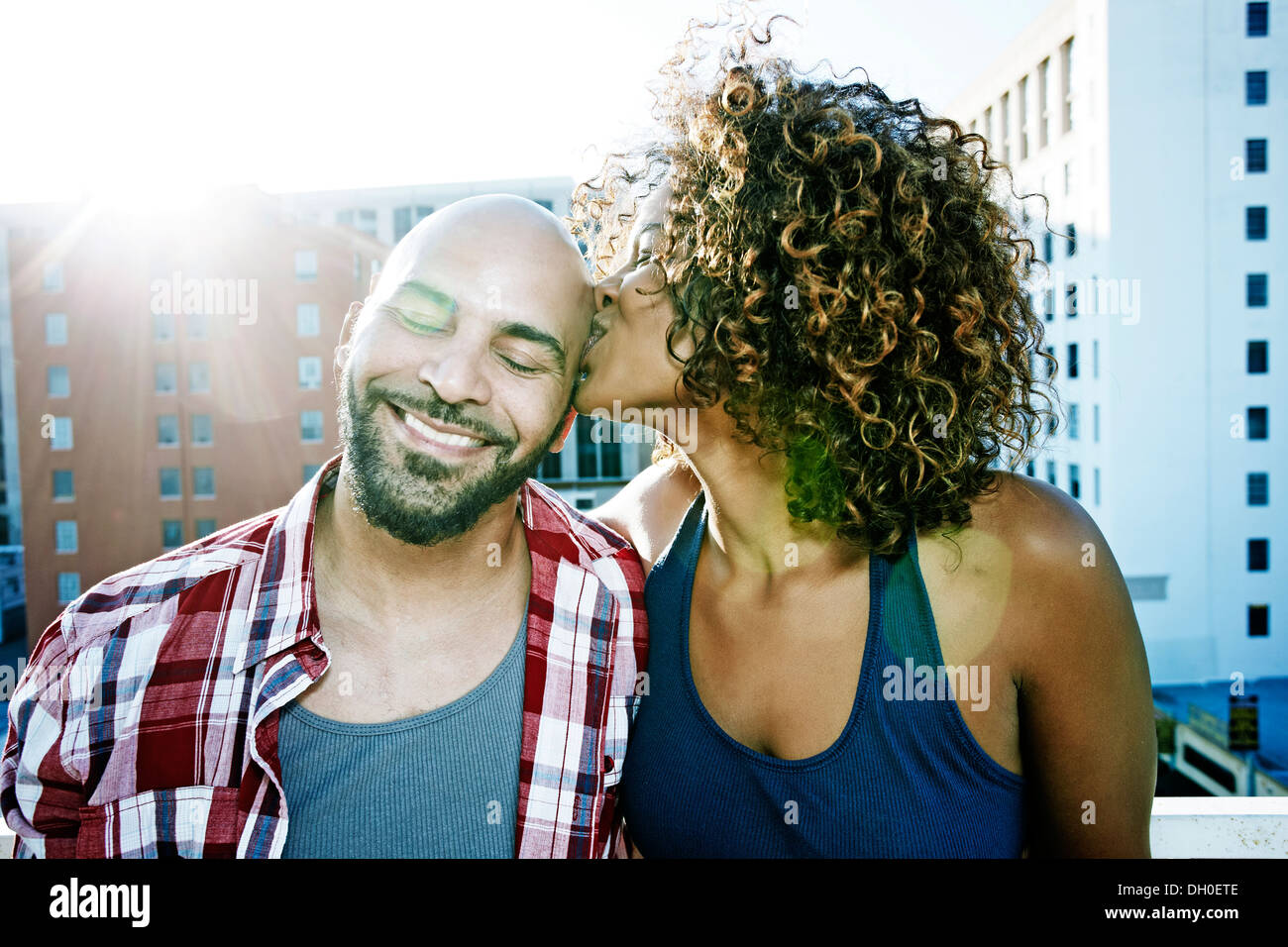 Couple kissing on urban rooftop Stock Photo