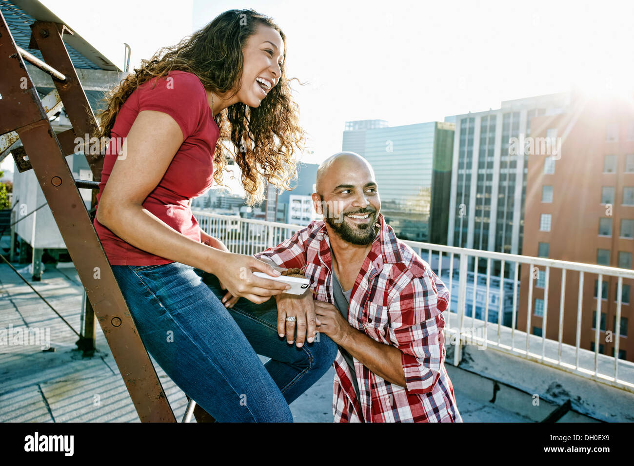 Couple relaxing on urban rooftop Stock Photo