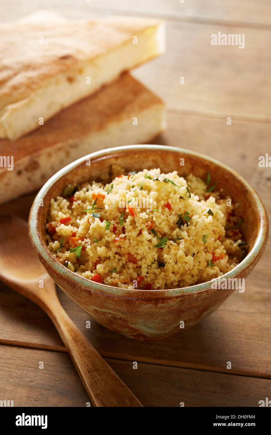 Cold cous cous salad with vegetables in ceramic bowl Stock Photo