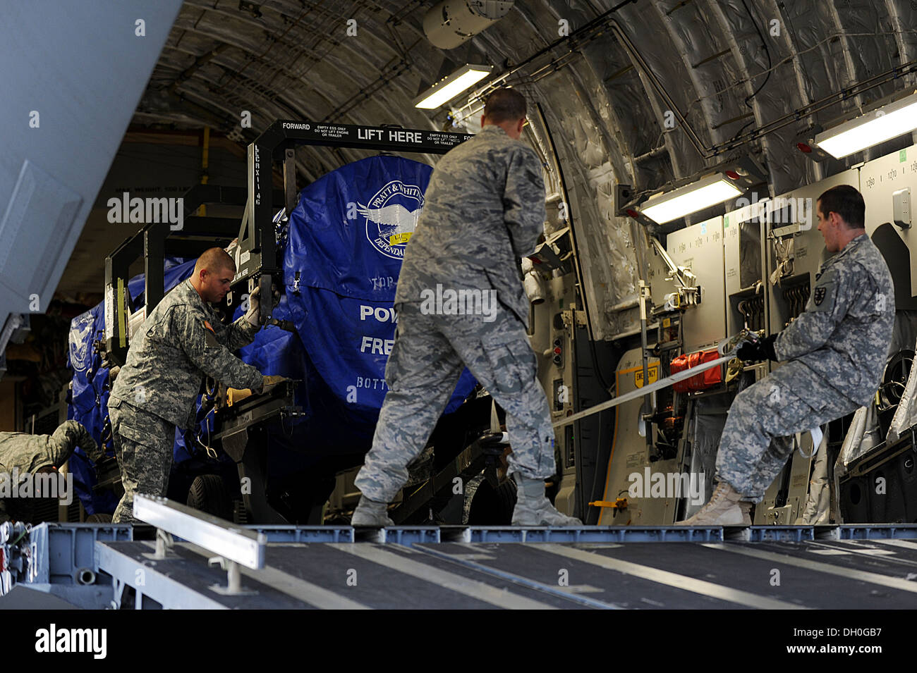 U.S. Army Soldiers, from the 622nd Movement Control Detachment from Fort Eustis, Va., and U.S. Air Force Airmen from the 633rd Logistics Readiness Squadron work together to unload cargo from a C-17 Globemaster III at Langley Air Force Base, Va., Oct. 23, Stock Photo