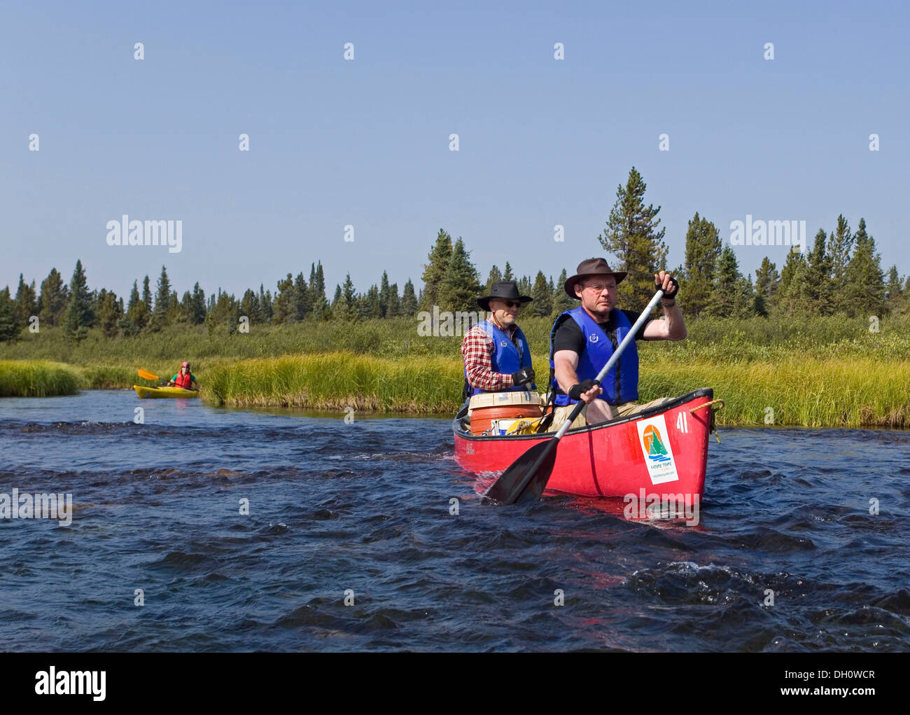 Two men in canoe, paddling, canoeing, Caribou Lakes, Kayak behind, upper Liard River, Yukon Territory, Canada Stock Photo