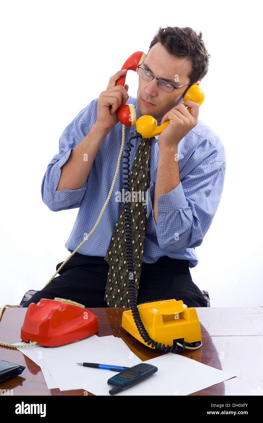 Busy businessman talking on two telephones in the same time Stock Photo