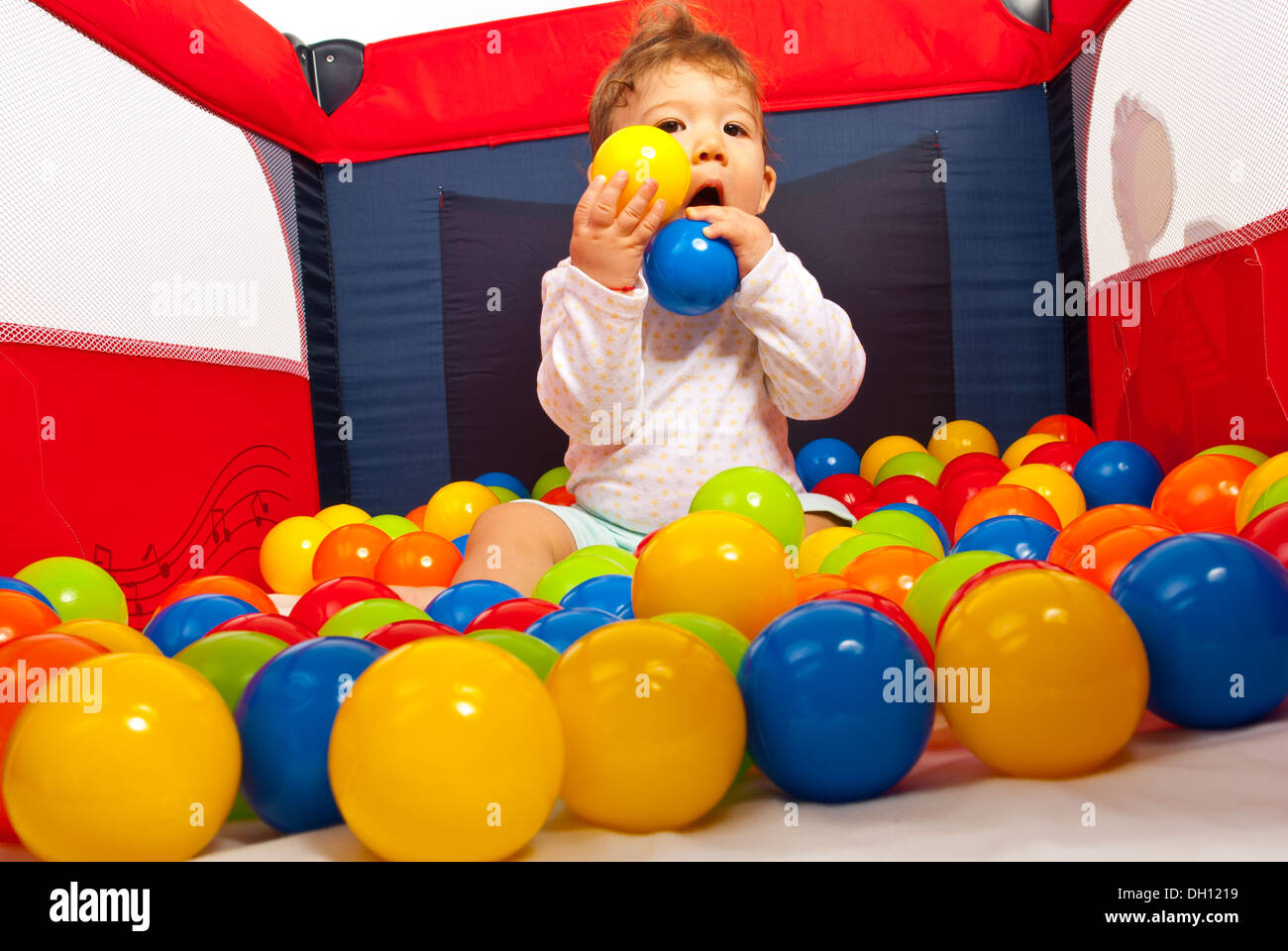 Baby boy playing with balls in playpen Stock Photo Alamy