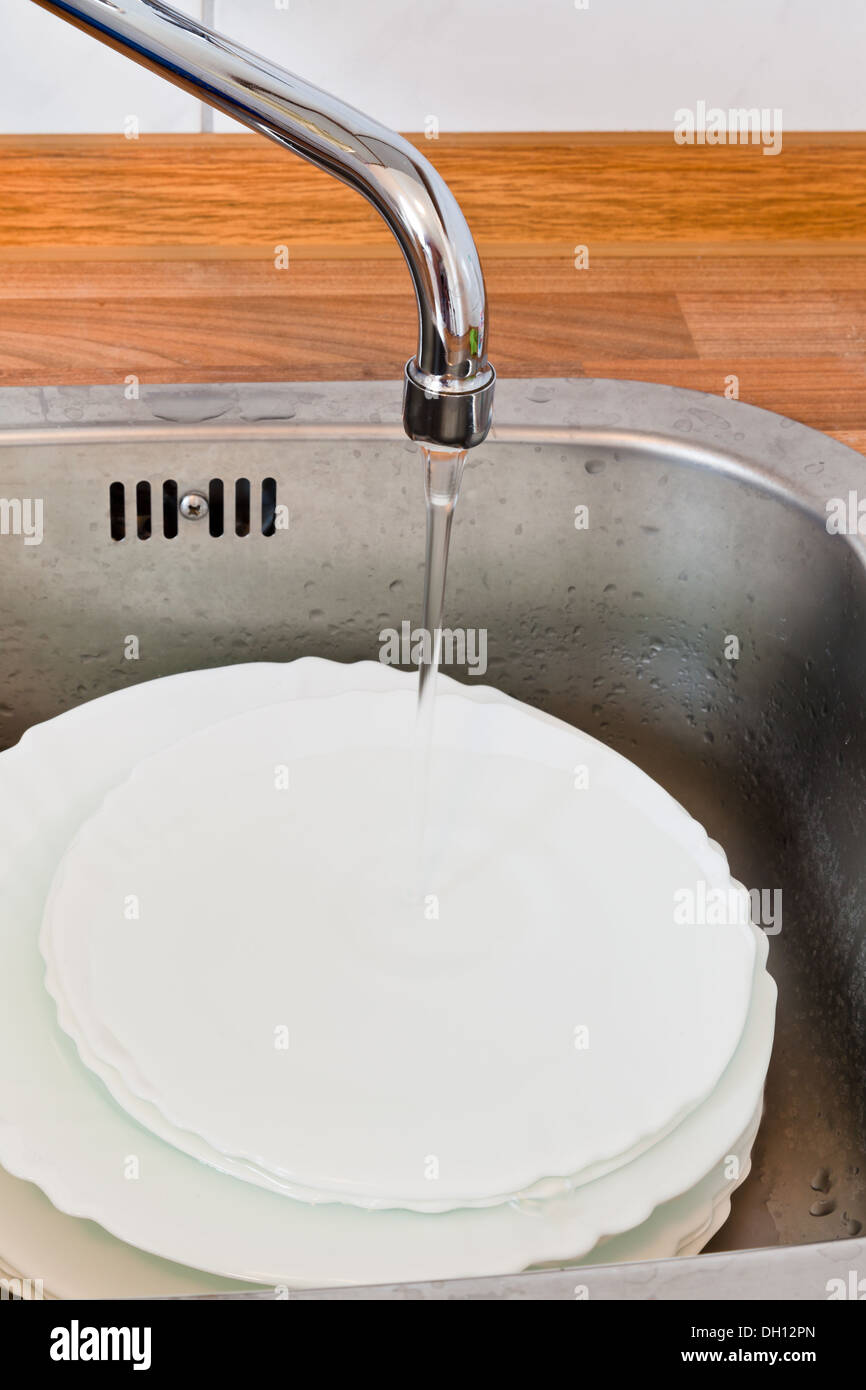wash-up in metal washbasin in kitchen Stock Photo
