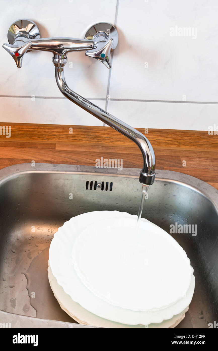 washing-up in metal washbasin in kitchen Stock Photo