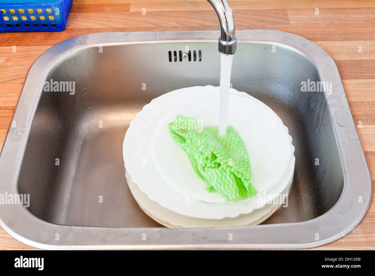 wash-up by dishcloth in metal washbasin in kitchen Stock Photo