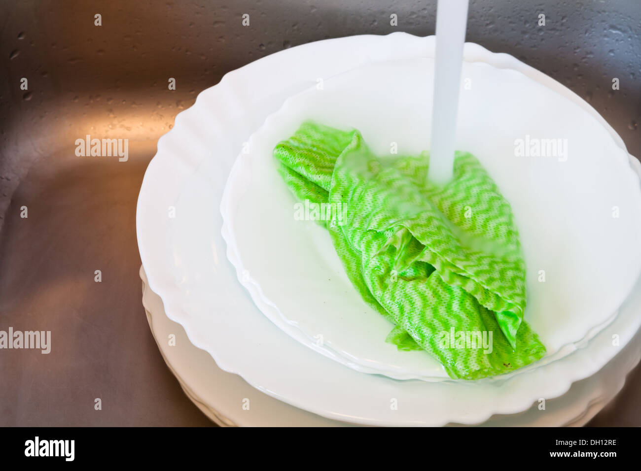 washing-up by dishcloth in metal washbasin in kitchen Stock Photo