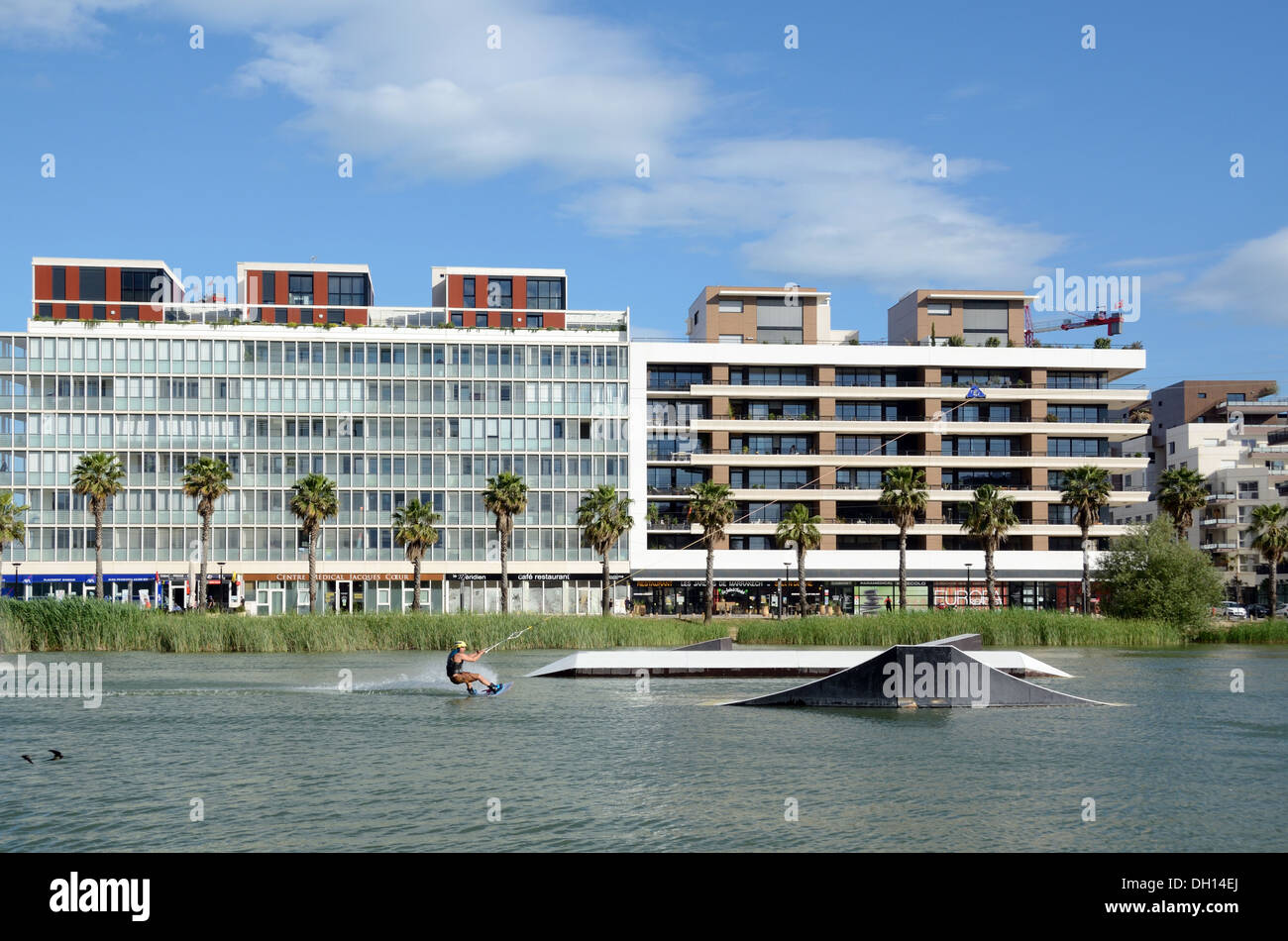 Water Skiing on Bassin Jacques Coeur & Modern Apartments in the Parc Marianne District, a New District or Suburb of Montpellier France Stock Photo