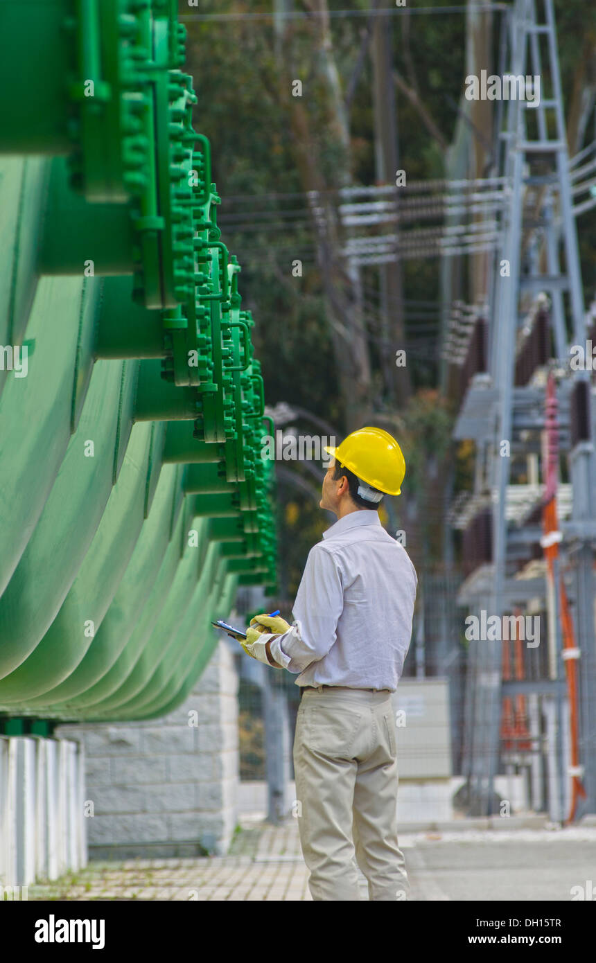 Hispanic worker checking tanks Stock Photo