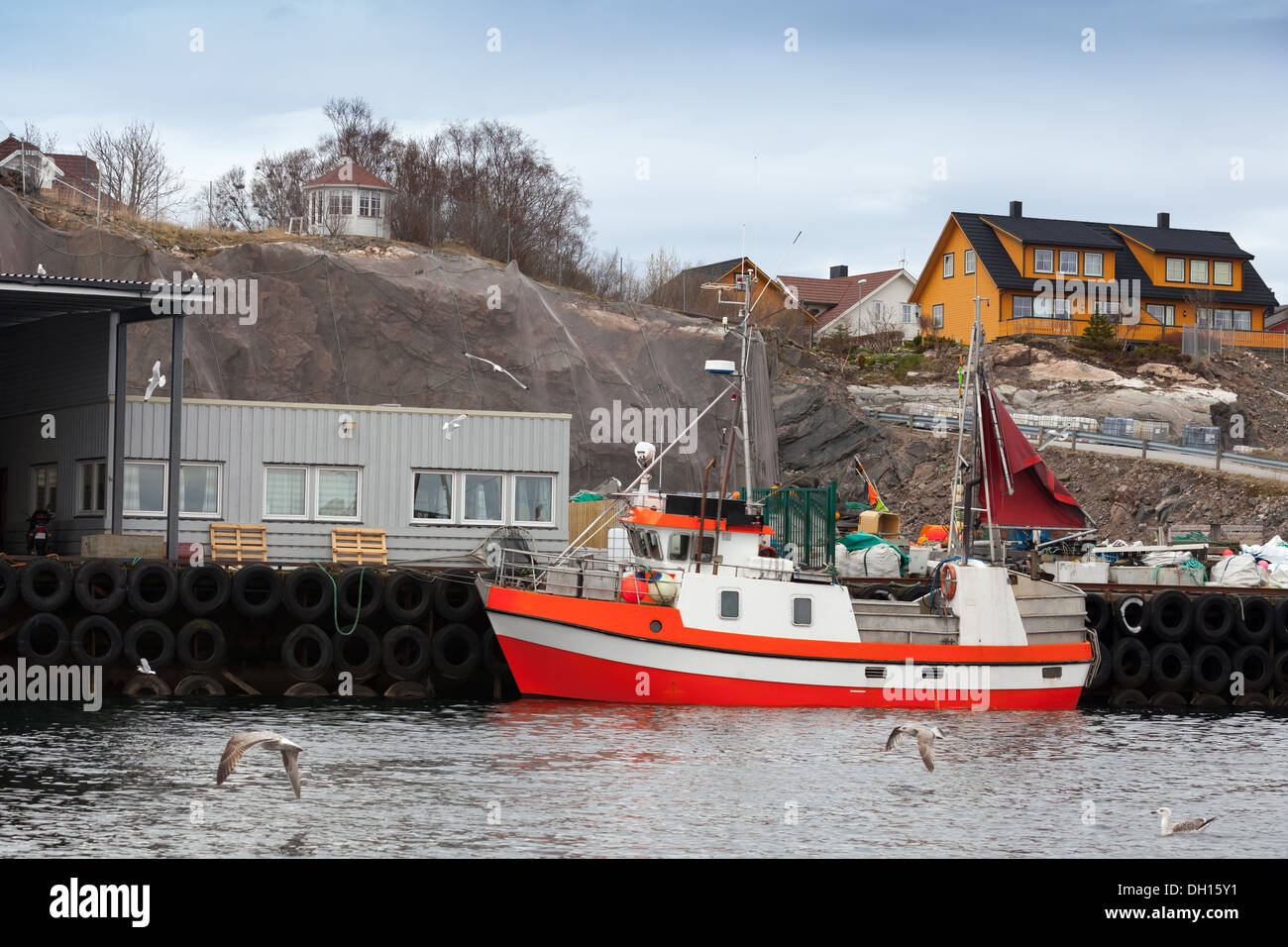 Small red and white fishing boat stands moored in Norway Stock Photo