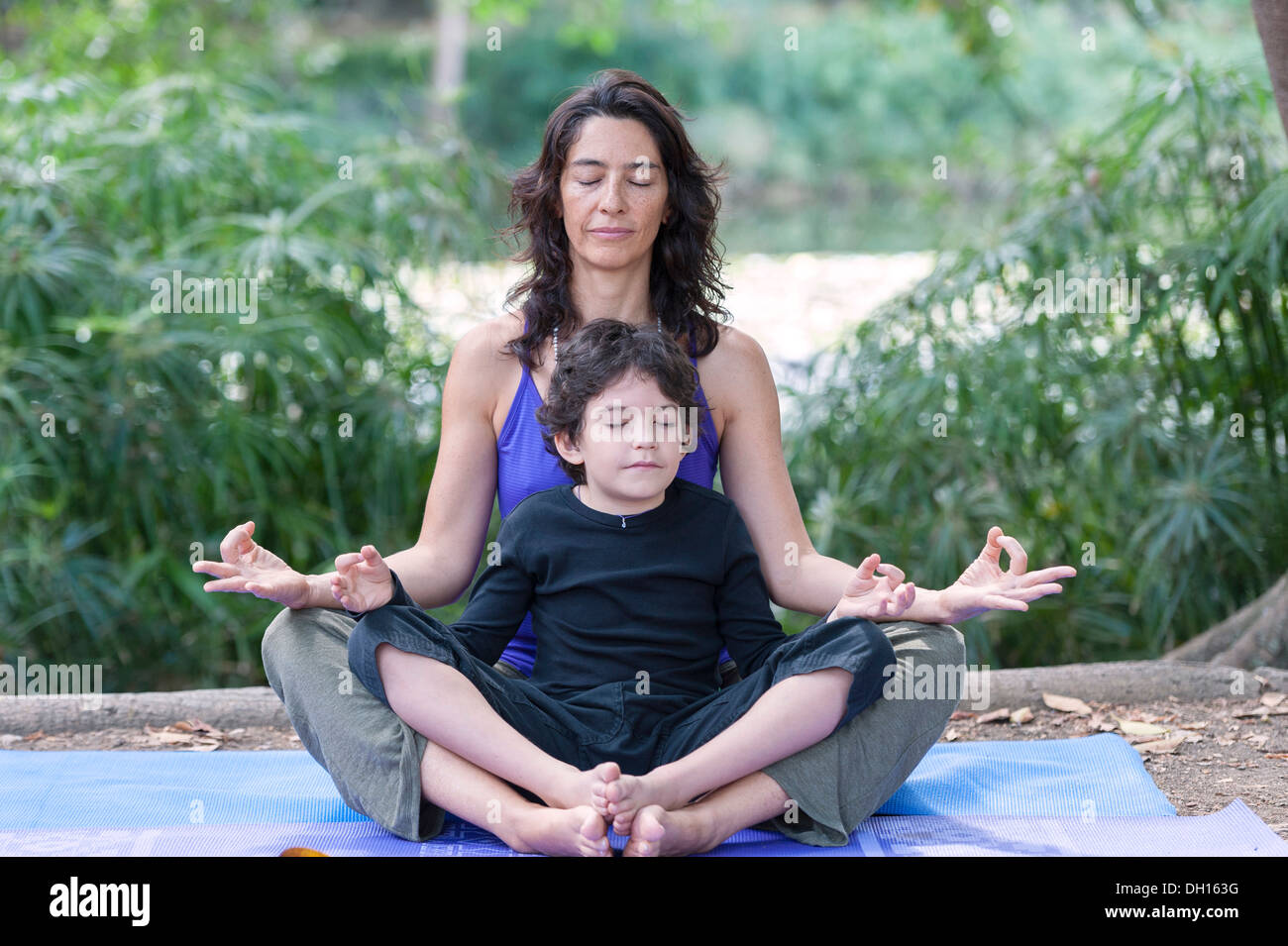 Hispanic mother and son practicing yoga Stock Photo