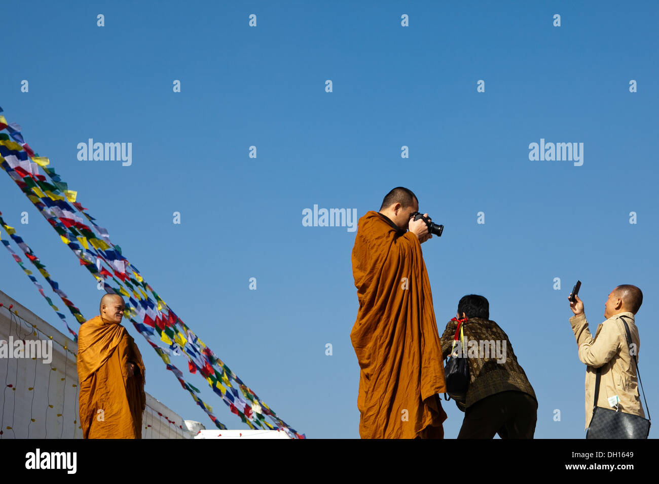 Monks and tourists with cameras Bodhanath / Bodnath Buddhist temple Kathmandu Nepal - juxtaposition of religion and technology Stock Photo