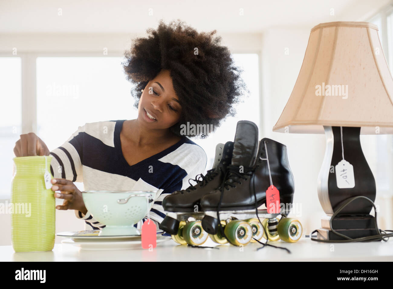 Mixed race woman putting price tag on items Stock Photo