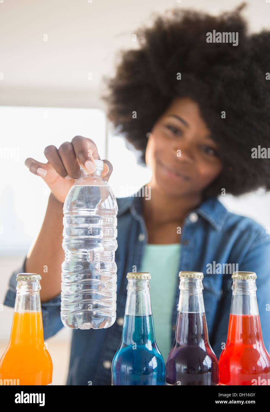 Mixed race woman choosing water over soda Stock Photo