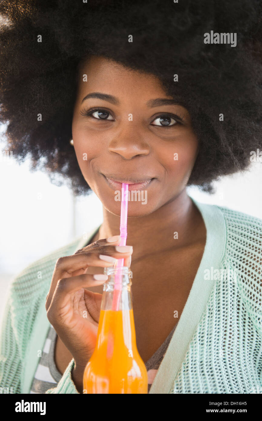 Mixed race woman drinking soda Stock Photo