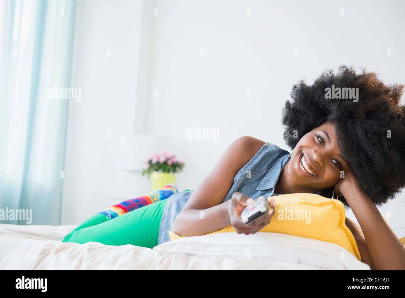 Mixed race woman watching television Stock Photo
